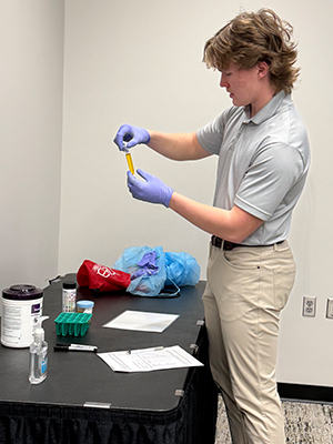 student looks at test tube